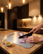 Slicing red onion on the titanium cutting board in a modern kitchen at night