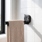 Suction clothes hanger on bathroom tiles holding a bath towel