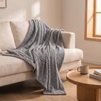 Grey milk fleece blanket draped over a sofa