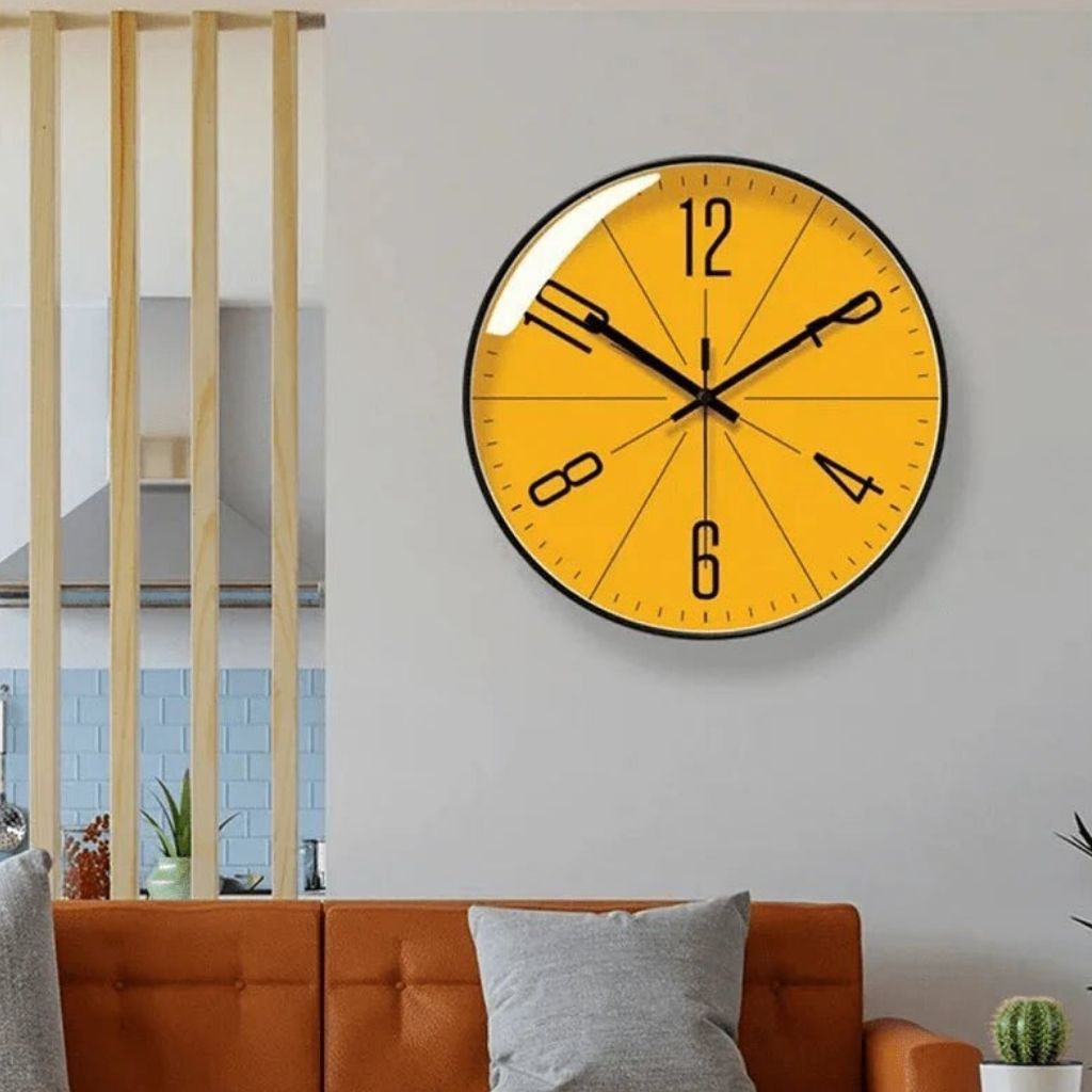 Modern Nordic wall clock with orange face above a sofa