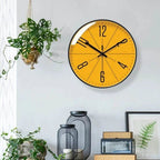 Modern Nordic wall clock with orange face hanging beside plants