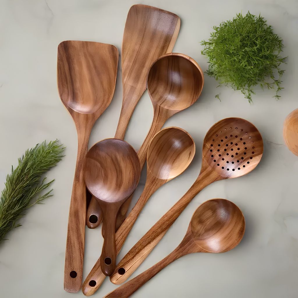 Teak wooden utensils with herbs on a kitchen bench