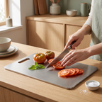 Titanium cutting board in use, slicing tomatoes on a kitchen bench